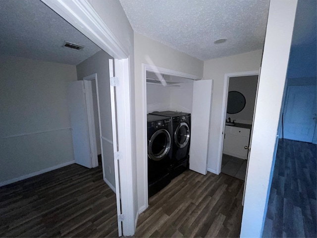 laundry area with washer and dryer, dark hardwood / wood-style floors, and a textured ceiling