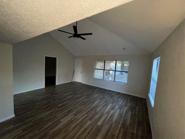 unfurnished living room featuring dark hardwood / wood-style floors, vaulted ceiling, a textured ceiling, and ceiling fan