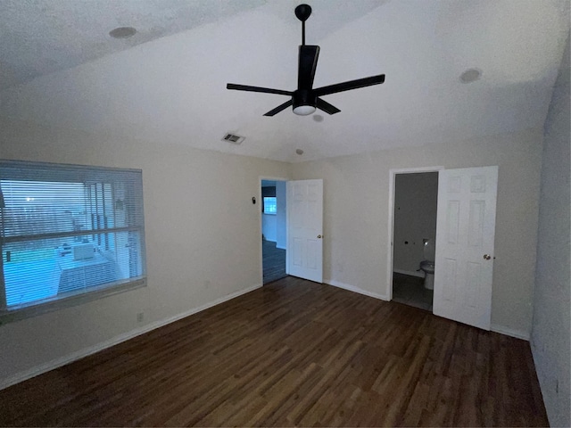 unfurnished bedroom featuring lofted ceiling, ceiling fan, dark hardwood / wood-style floors, and a textured ceiling