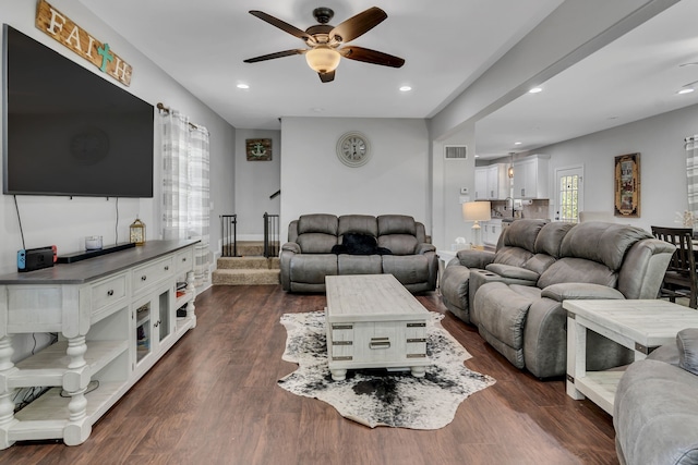 living room featuring dark wood-type flooring and ceiling fan