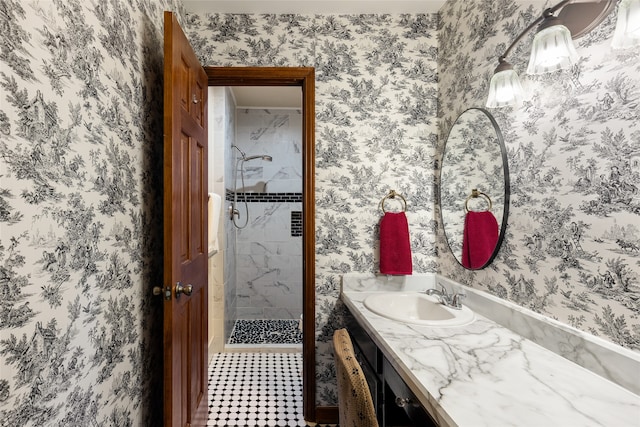 bathroom featuring a tile shower and vanity