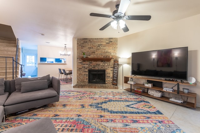 tiled living room with a fireplace and ceiling fan with notable chandelier