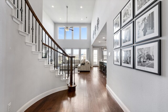 entryway featuring dark hardwood / wood-style floors, ceiling fan, and a towering ceiling