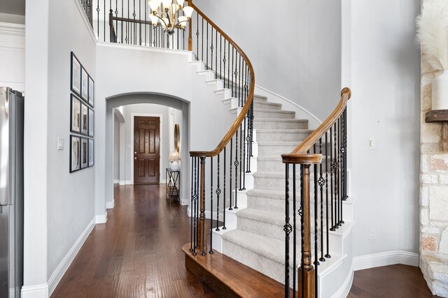 entryway featuring dark hardwood / wood-style flooring, a high ceiling, and an inviting chandelier