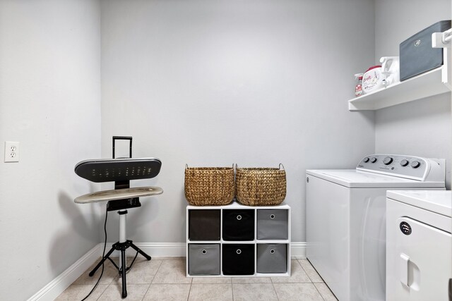 laundry room featuring separate washer and dryer and light tile patterned floors