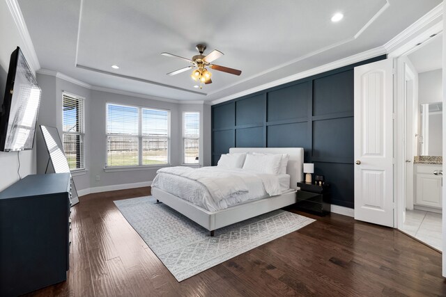 bedroom featuring ensuite bath, ceiling fan, dark wood-type flooring, and ornamental molding