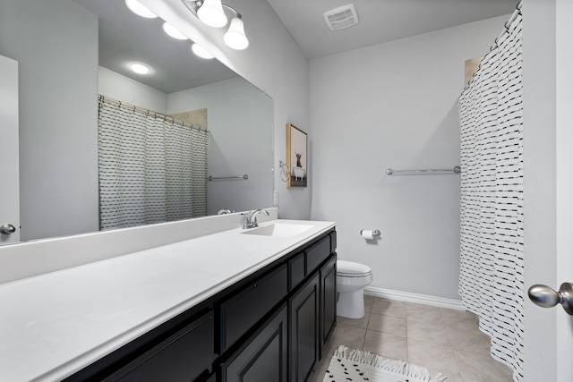 bathroom featuring tile patterned flooring, vanity, toilet, and walk in shower