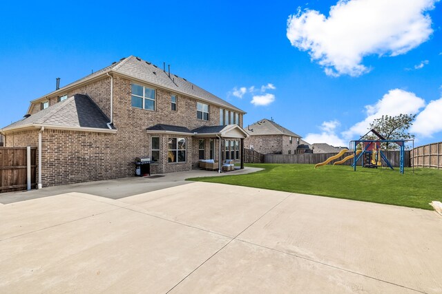 rear view of house featuring a playground, a patio area, and a lawn