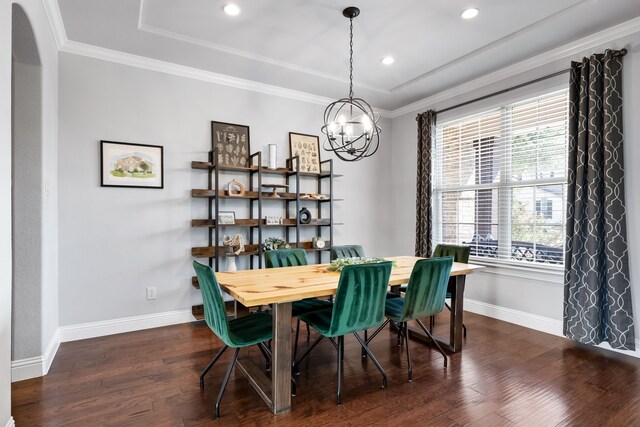 dining space with crown molding, dark wood-type flooring, and a notable chandelier