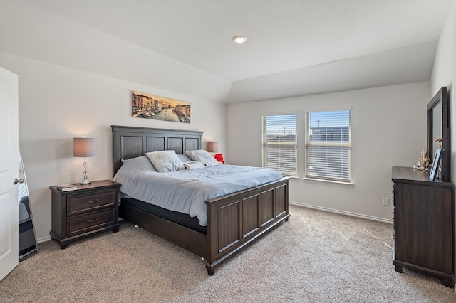 bedroom featuring light colored carpet and lofted ceiling