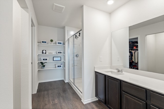 bathroom featuring hardwood / wood-style floors, vanity, and a shower with shower door