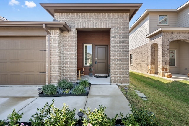 entrance to property featuring a yard and a garage