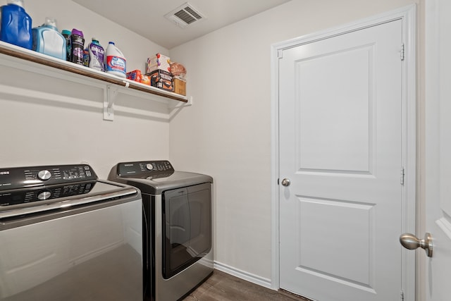 laundry room featuring washer and dryer and dark hardwood / wood-style flooring