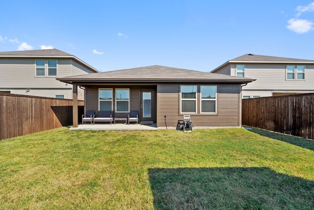 rear view of house featuring a lawn and a patio