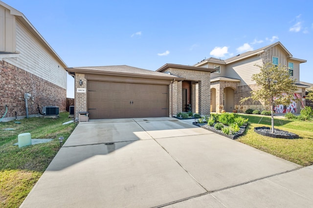 view of front of home featuring a garage, a front lawn, and central AC unit