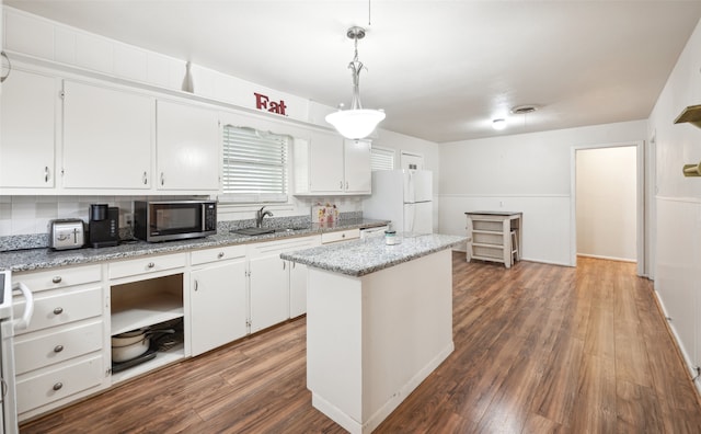 kitchen with a kitchen island, dark wood-type flooring, hanging light fixtures, white refrigerator, and white cabinetry