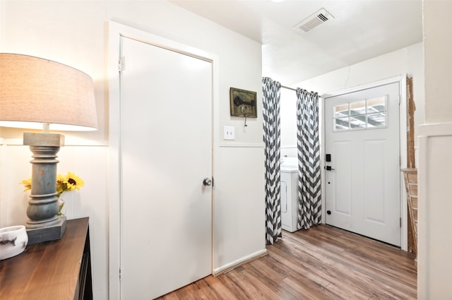 entryway with wood-type flooring and washer / clothes dryer