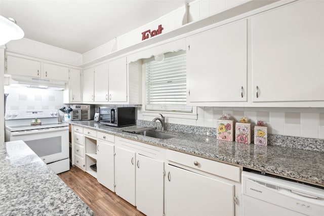 kitchen with white appliances, sink, white cabinets, hardwood / wood-style flooring, and decorative backsplash