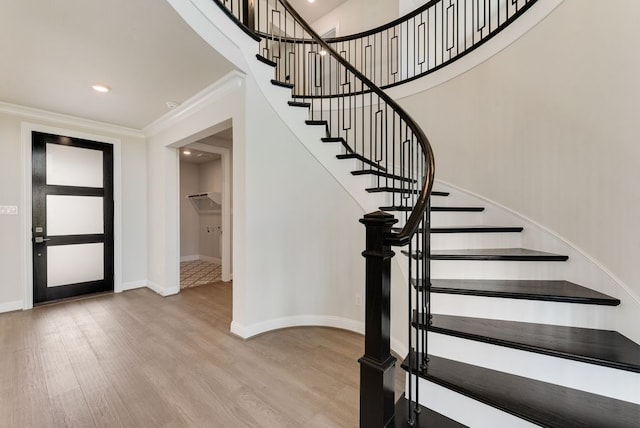 entrance foyer with baseboards, ornamental molding, wood finished floors, stairs, and recessed lighting