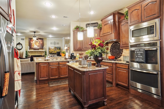 kitchen with hanging light fixtures, kitchen peninsula, dark hardwood / wood-style flooring, and a center island