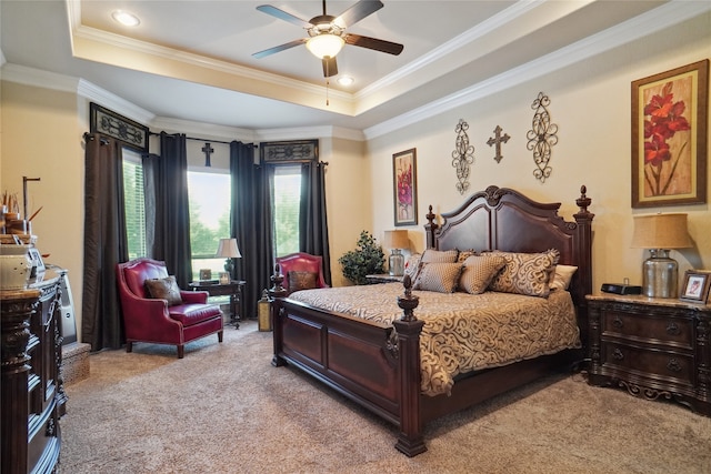 carpeted bedroom with ornamental molding, ceiling fan, and a tray ceiling