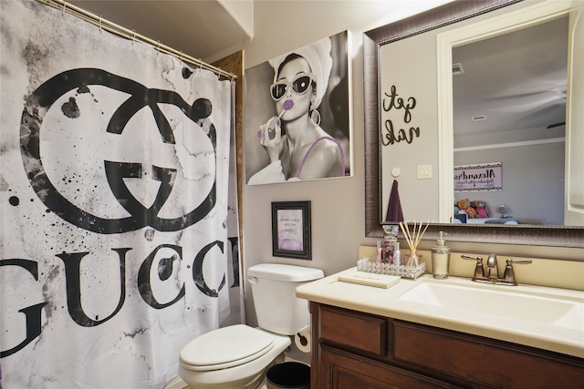 bathroom featuring ornamental molding, vanity, toilet, and curtained shower