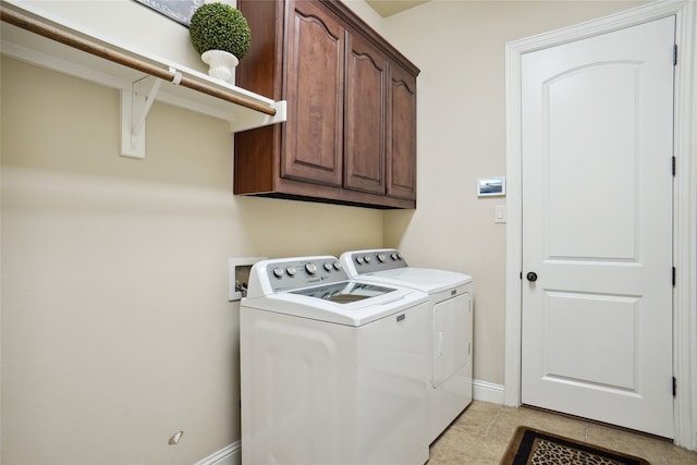 laundry room with washing machine and dryer and cabinets