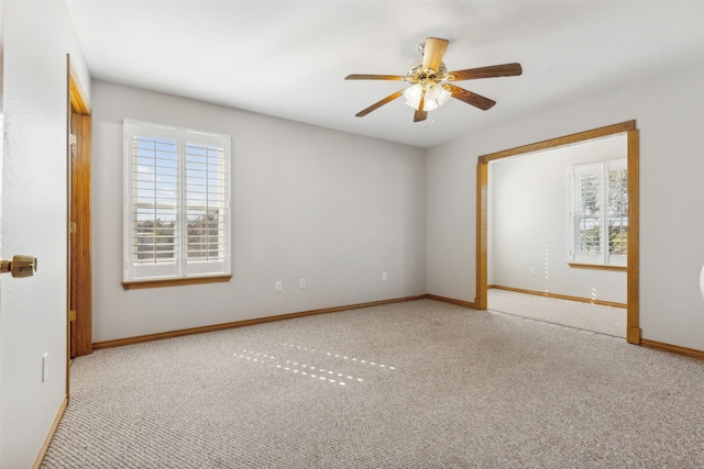 spare room with ceiling fan, light carpet, and a wealth of natural light