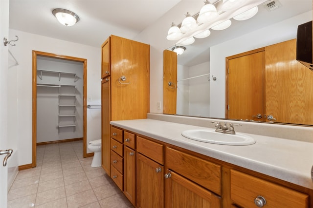 bathroom featuring a shower, tile patterned floors, vanity, and toilet