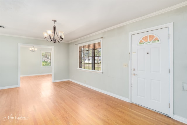 entryway with ornamental molding, a chandelier, and light hardwood / wood-style flooring