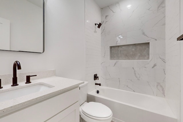 full bathroom with vanity, tiled shower / bath combo, and toilet