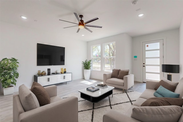 living room with ceiling fan and light hardwood / wood-style flooring