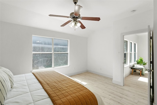 bedroom featuring light wood-type flooring, multiple windows, ceiling fan, and lofted ceiling