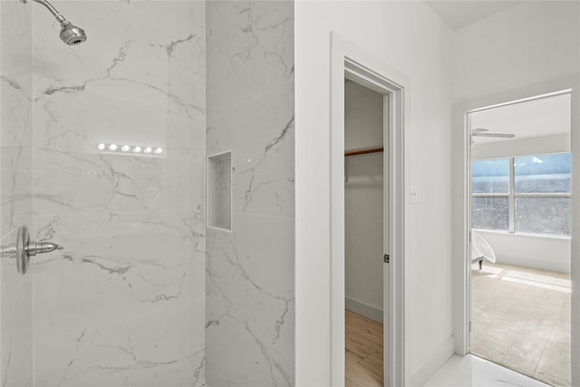 bathroom with ceiling fan, hardwood / wood-style floors, and a tile shower