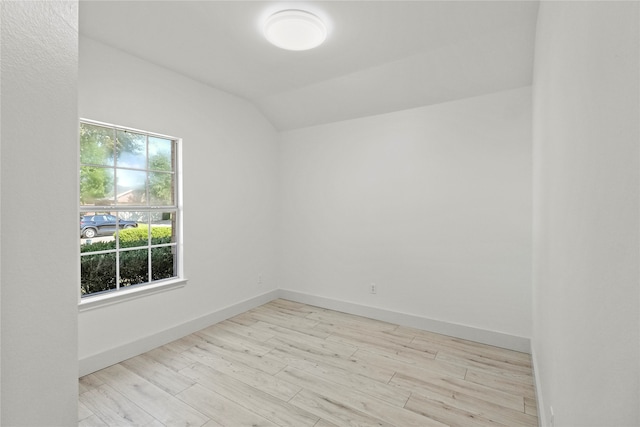 unfurnished room featuring lofted ceiling and light hardwood / wood-style floors