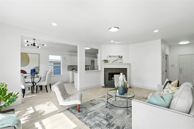 living room with a tile fireplace and light hardwood / wood-style flooring