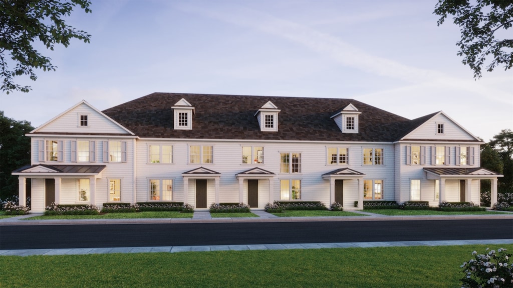 view of front of property featuring a balcony and a front lawn