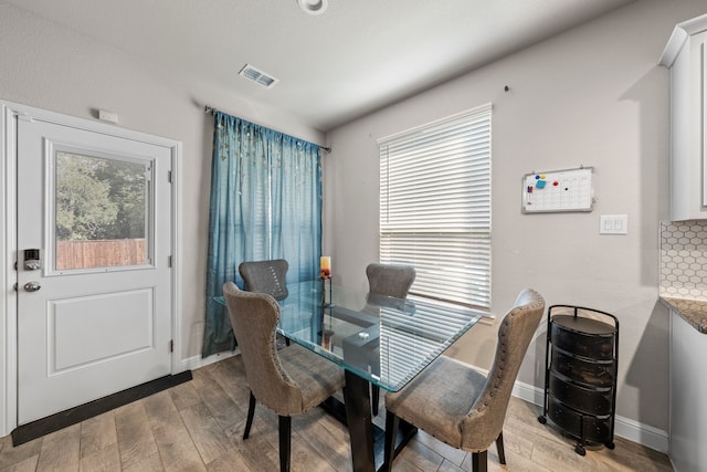 dining space with plenty of natural light and light hardwood / wood-style flooring