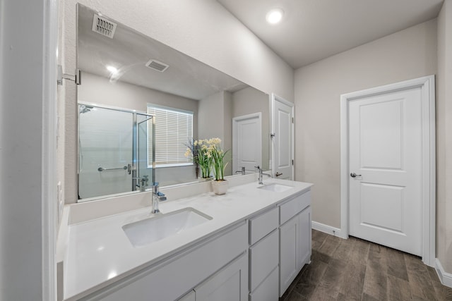 bathroom with vanity and a shower with door