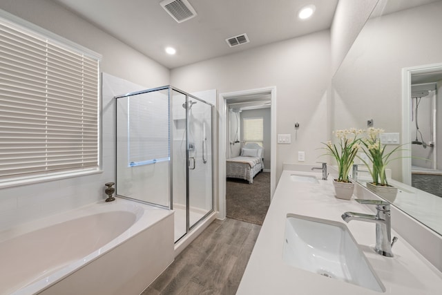 bathroom featuring wood-type flooring, vanity, and plus walk in shower