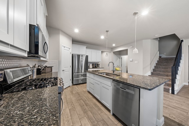 kitchen featuring hanging light fixtures, white cabinetry, appliances with stainless steel finishes, and sink