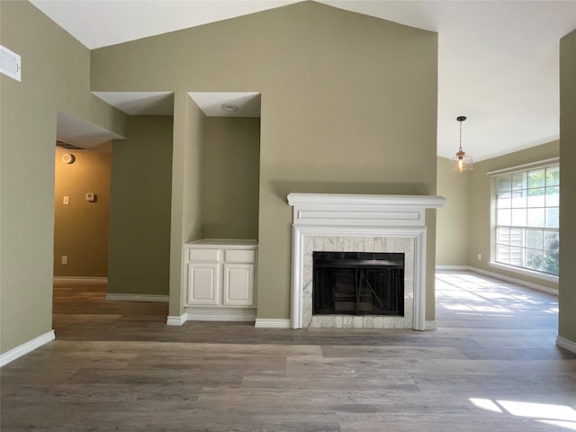 unfurnished living room with high vaulted ceiling and light wood-type flooring