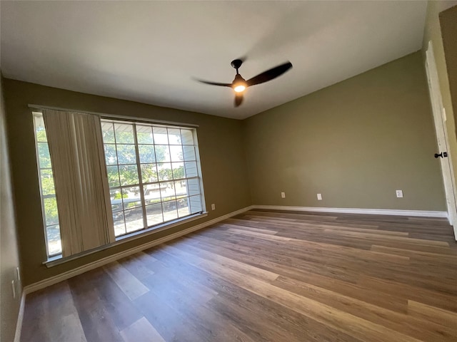 spare room featuring dark hardwood / wood-style flooring and ceiling fan