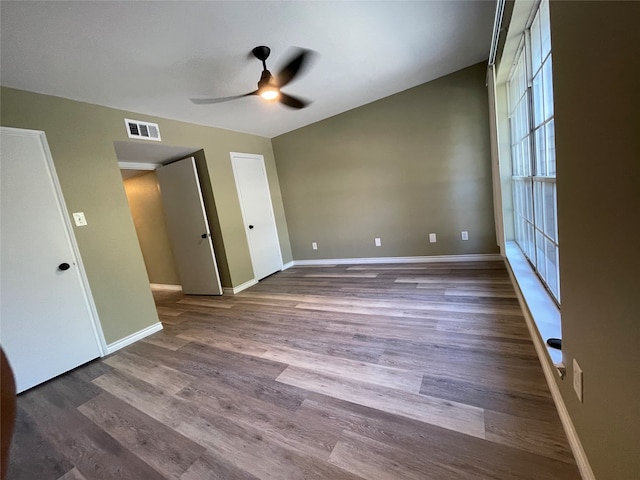 unfurnished bedroom with ceiling fan, dark wood-type flooring, and vaulted ceiling