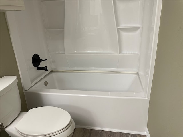 bathroom with bathtub / shower combination, wood-type flooring, and toilet