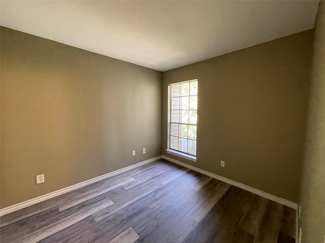 unfurnished room with dark wood-type flooring