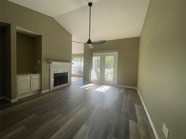 unfurnished living room featuring lofted ceiling, french doors, ceiling fan, dark hardwood / wood-style flooring, and a tiled fireplace