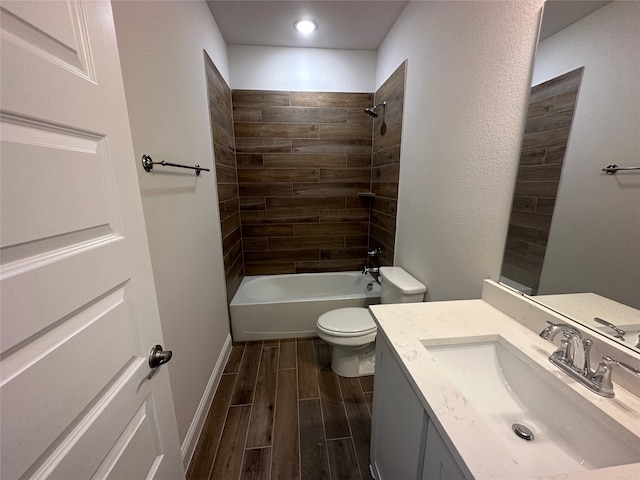 full bathroom featuring wood-type flooring, tiled shower / bath, vanity, and toilet