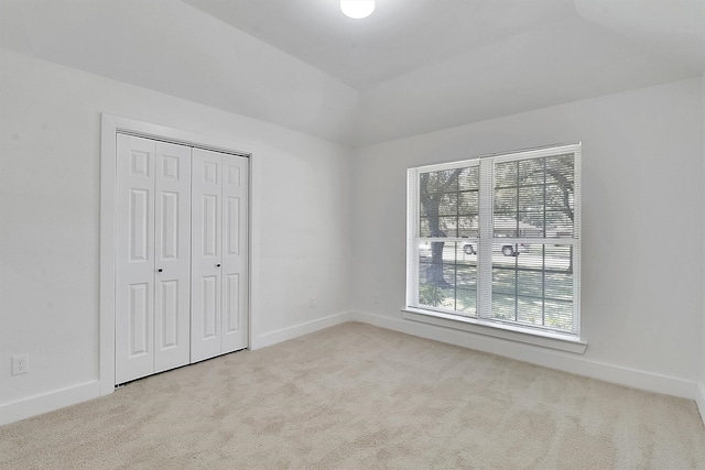 unfurnished bedroom with a closet and light carpet