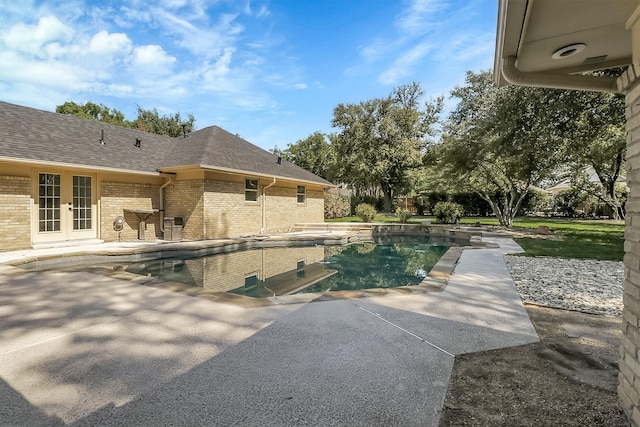 view of swimming pool with french doors and a patio area